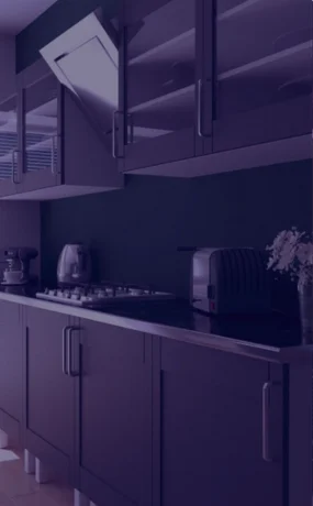 Modern kitchen with dark cabinets and appliances in a Tronica City Ghaziabad manufacturing facility.