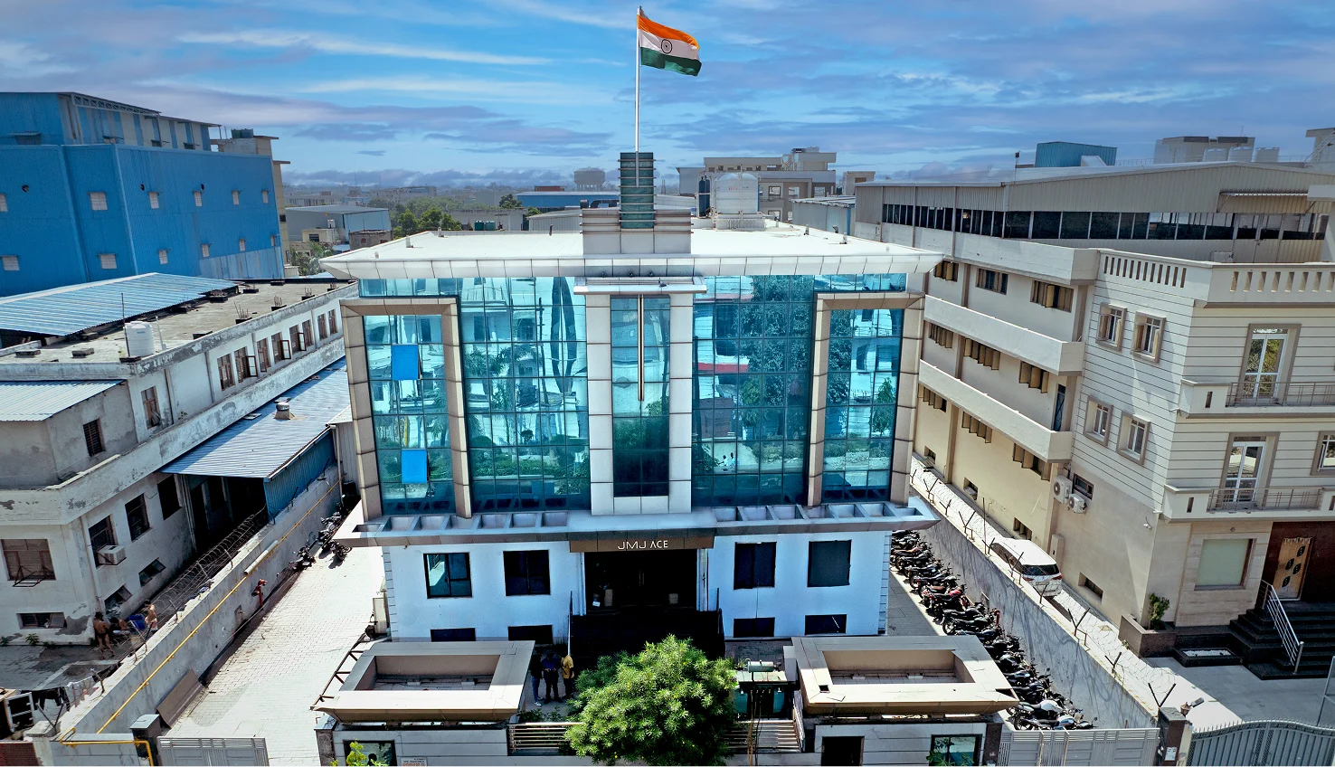Modern manufacturing facility for rent in Tronica City, Ghaziabad with glass facade and Indian flag.