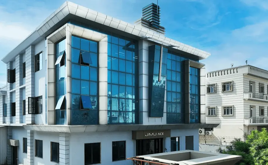 JMJ ACE commercial building by JMJ Estate featuring a modern glass facade in India.